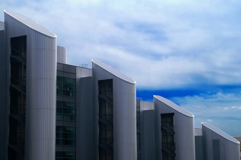 a row of buildings with blue and white clouds in the background