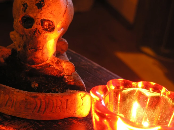 a little candle and some fake skulls on a table