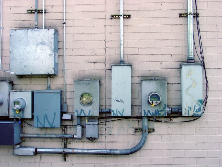 a wall with some electrical wires and electrical boxes attached to it
