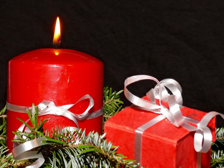 red candle and christmas decoration on black background