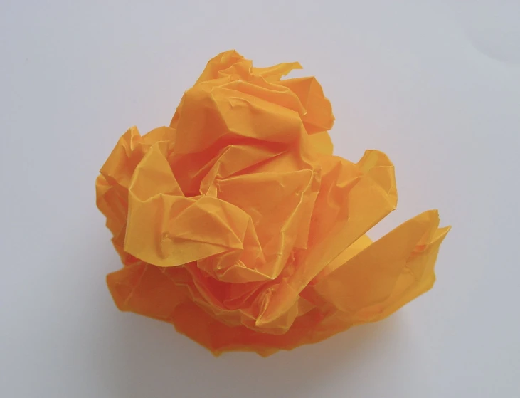 a large paper flower is made to look like an orange rose