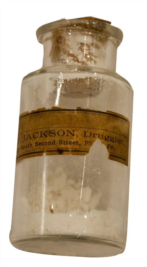 an old glass jar that contains an inky brown liquid