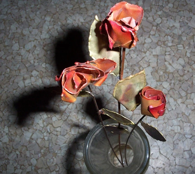 a glass vase containing several different colored roses