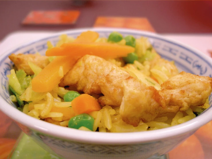 this is a bowl of noodles and fried fish