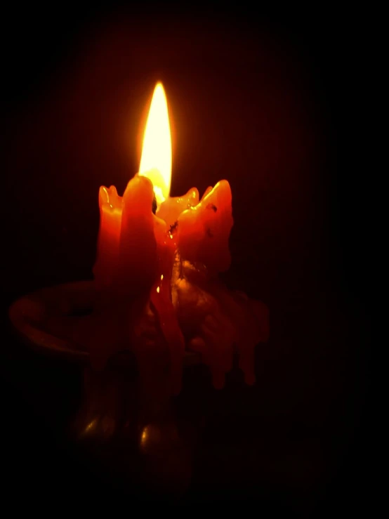 a close up of two lit candles on a table