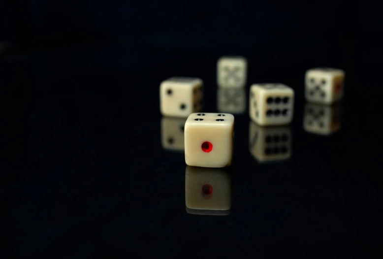 a set of white and black dices are on a black surface