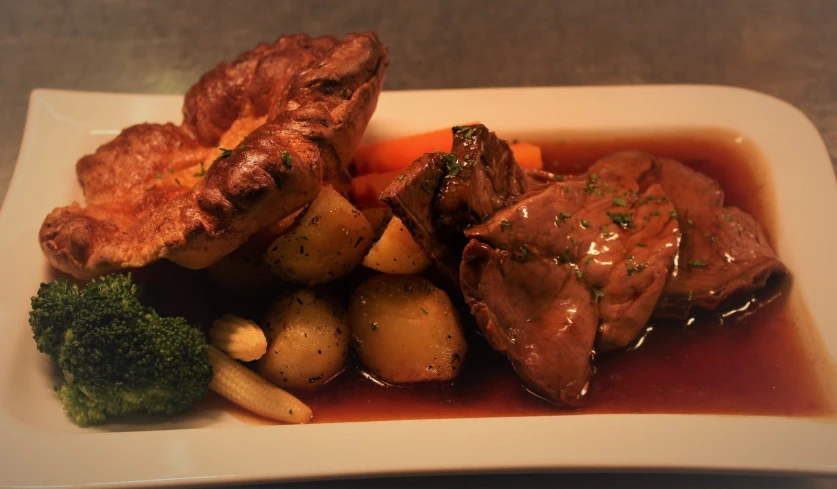 some food on a white plate with broccoli and potatoes