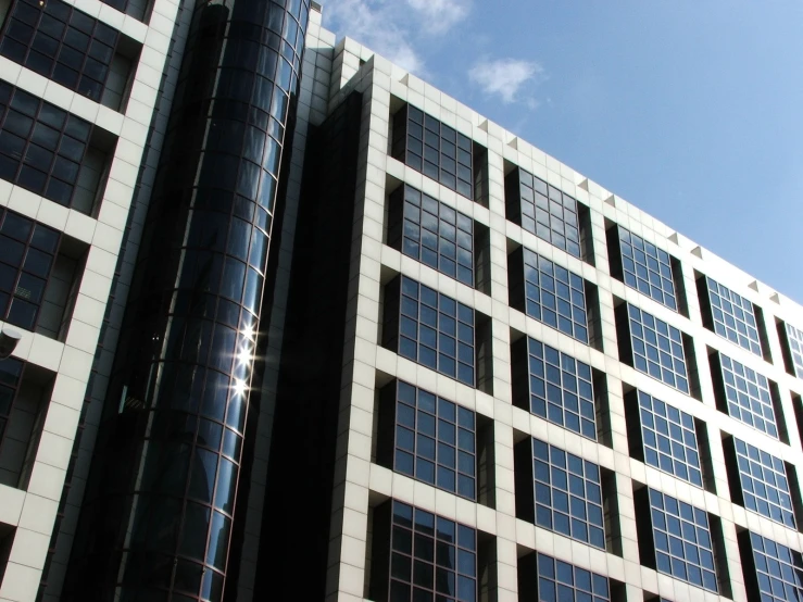 two tall buildings with multiple stories, each containing glass windows