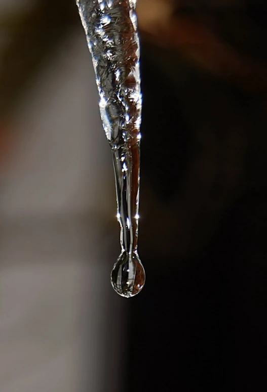 a close up view of an icicles with drops of water