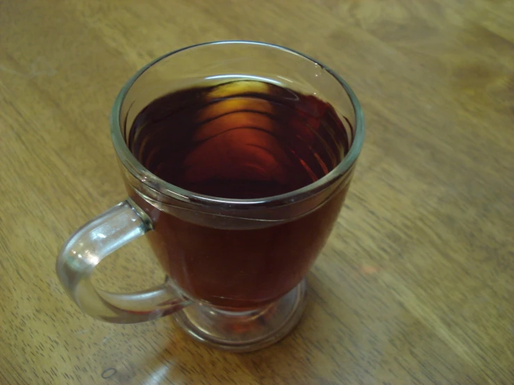 a cup of mulled tea in a glass mug on a wooden table