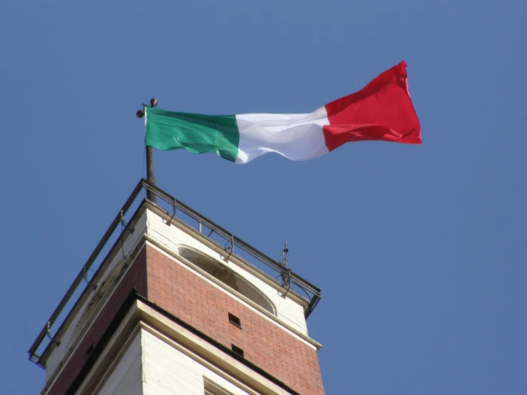 the flag is flying high on the roof of a building