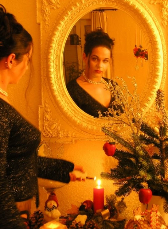 a woman prepares to decorate a christmas tree in a mirror