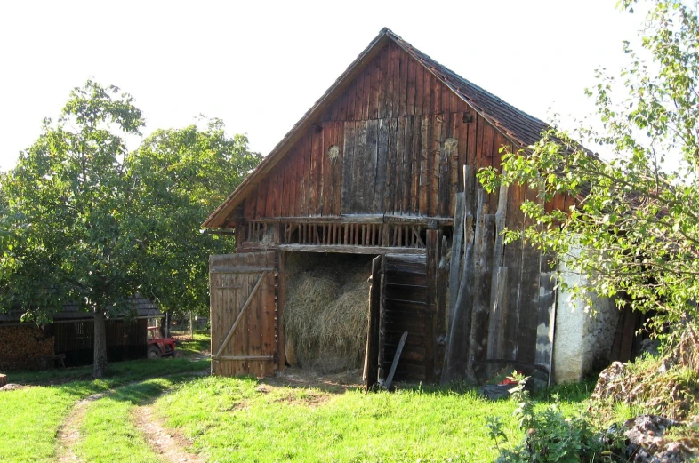 an old weathered barn with a barn on the corner