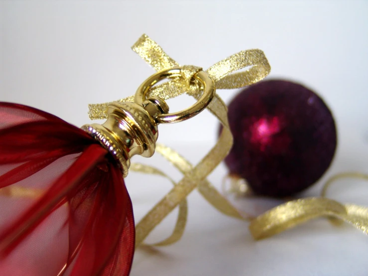 an ornament is attached to a metal ball and a red glass