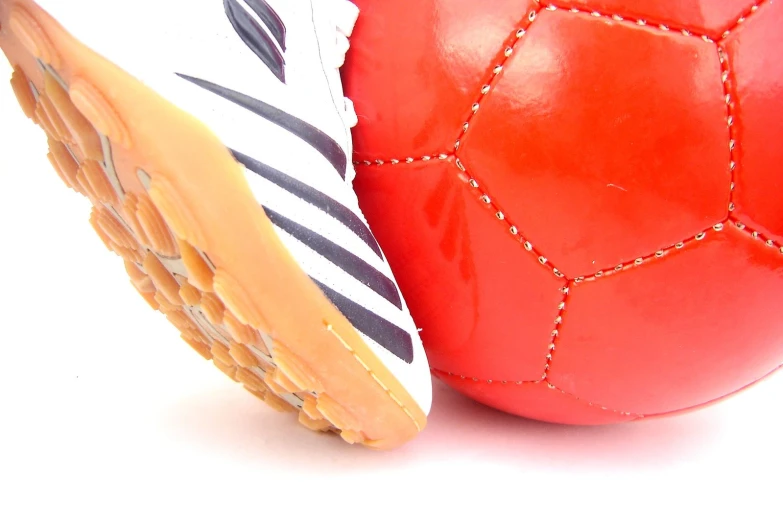 an orange and white football are beside each other