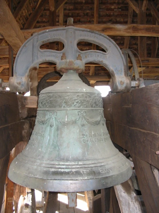 a large bell hanging from the ceiling inside a building