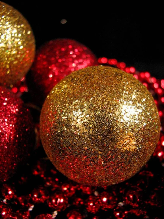 three golden balls of christmas lights in front of a dark background
