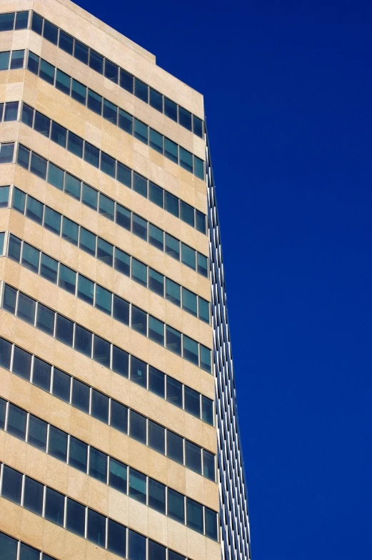 the top of a tall skyscr building against a clear blue sky