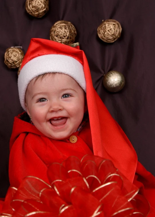 a smiling little boy is dressed as santa clause