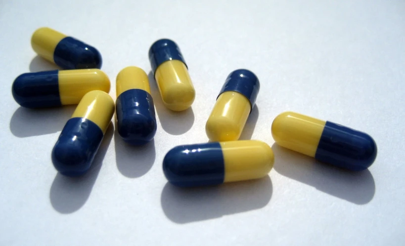 yellow and blue pills placed on a white table