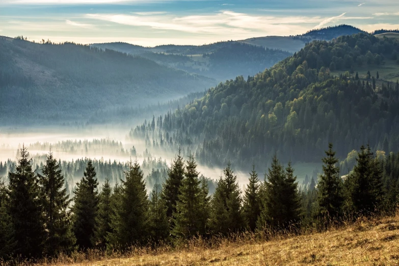 a view of the mountains from above, with fog in them