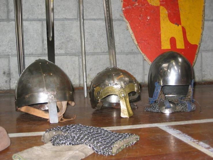 three ancient knights'helmets, one on display in a museum