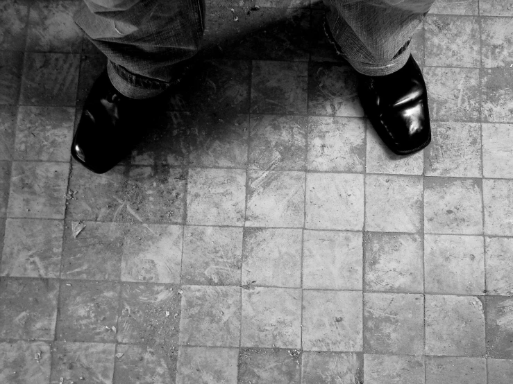 man in dress clothing and black shoes standing on tile