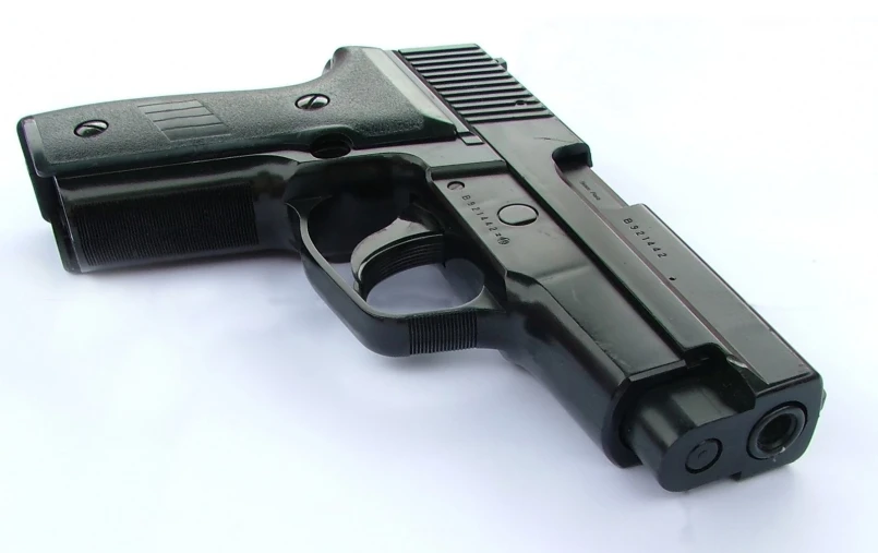 a black gun and its magazine on a white background