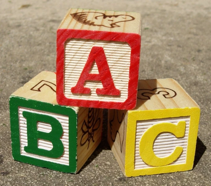 a toy block spelling a - c on the street