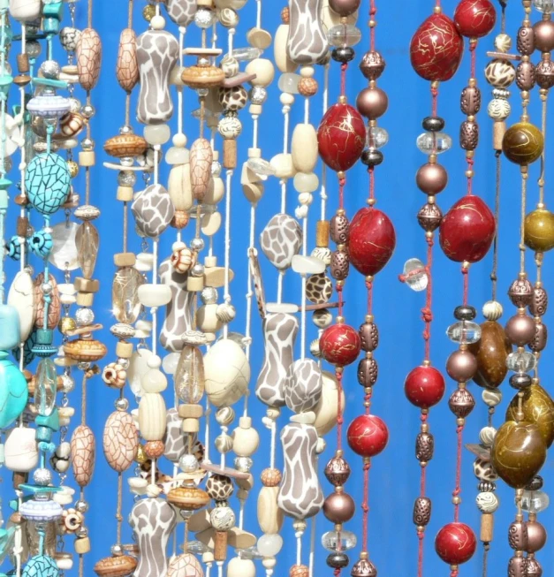a bunch of colorful balls and ornaments hang on a wall