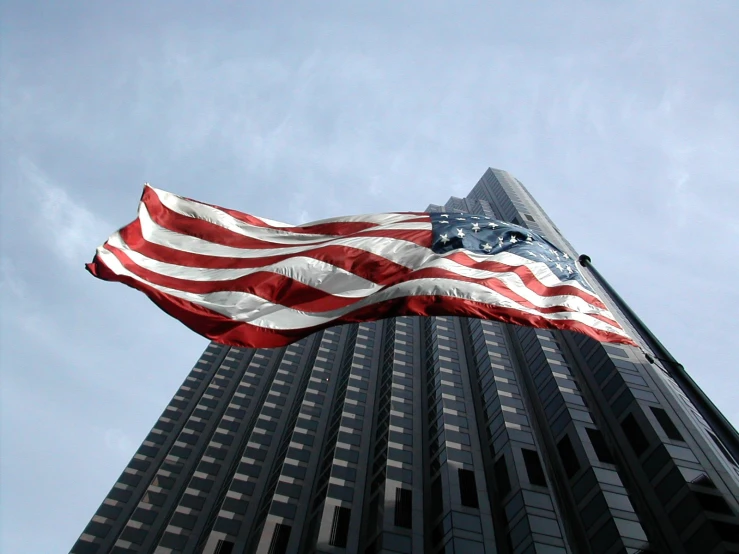 an american flag blowing in front of a building