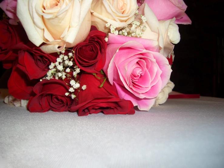 the bouquet of flowers has pink and red roses