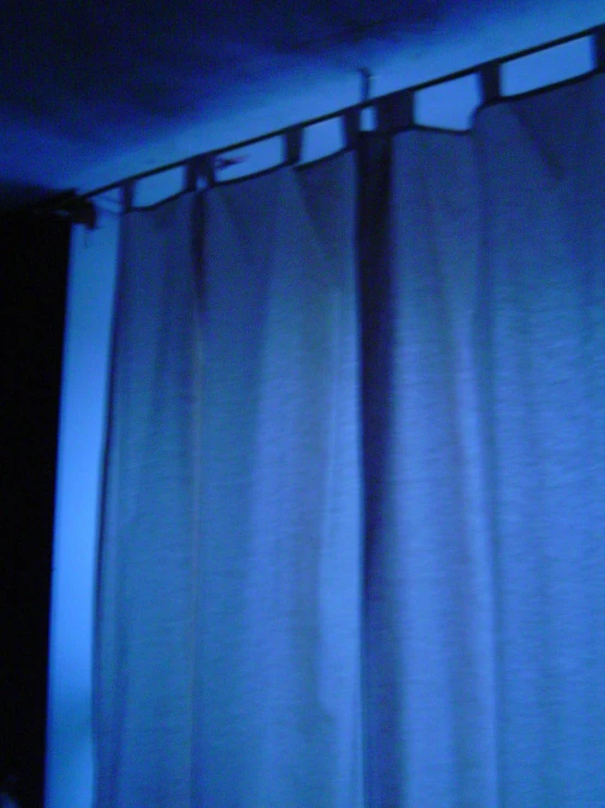 a curtain is partially obscured by the blue light