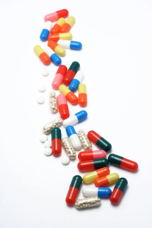 assortment of pills and tablets scattered in white background