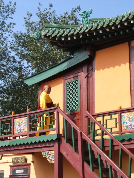 a man is standing on a porch near a building