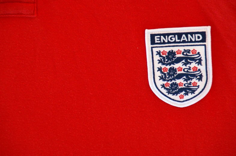 the england crest is on the red shirt