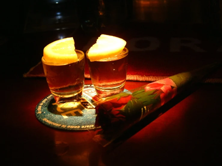 two glasses with beers and a bat on a table