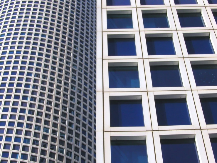 two tall buildings with square windows next to each other