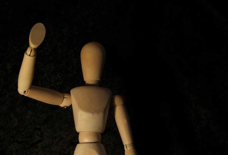 an old, wooden toy with two fingers extended