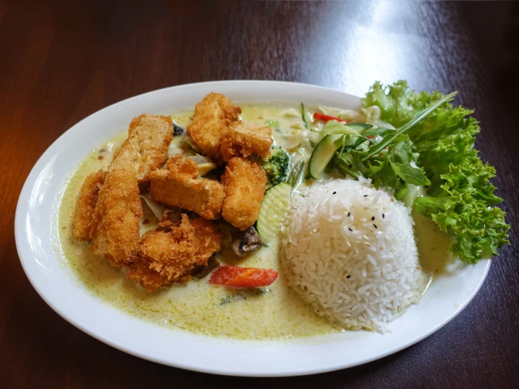 fish with rice and greens on a white plate