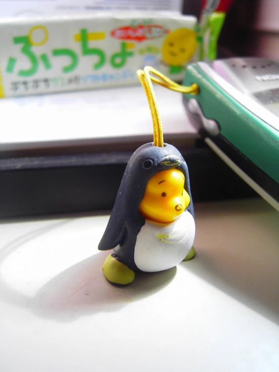 a penguin toy with a small doll hanging from it's back