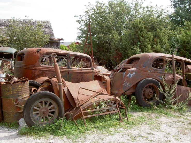 rusty old cars parked in a field outside