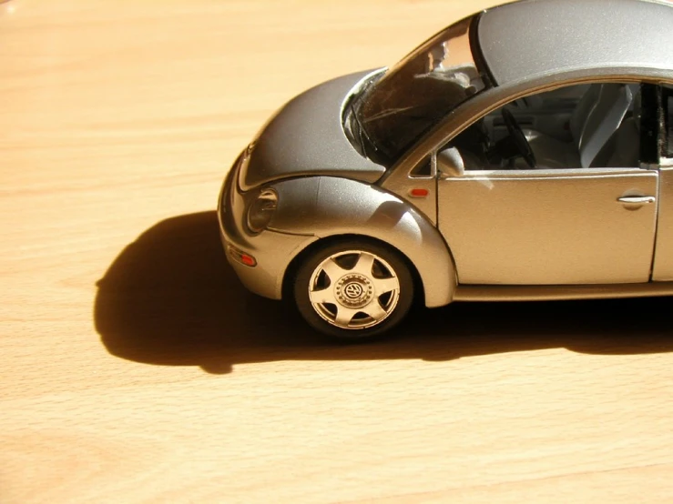 a toy car with wheels sitting on top of a wooden surface