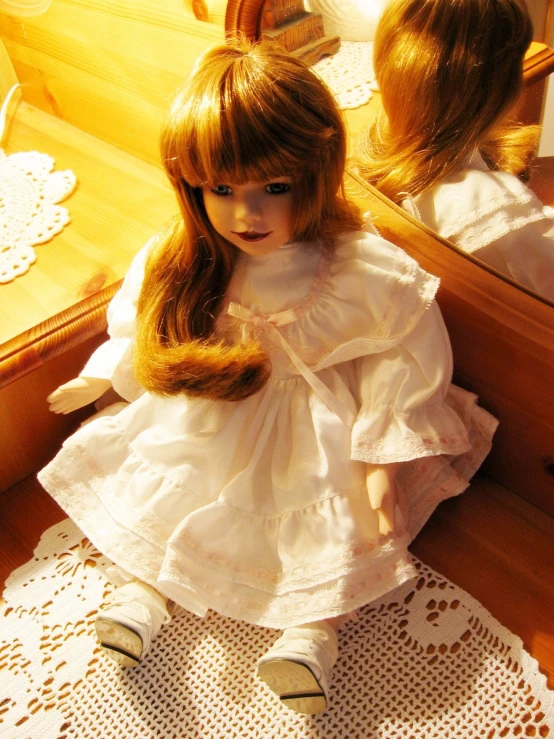 a doll with long hair is sitting in front of a mirror