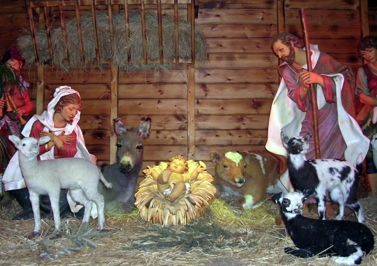 the christmas scene features fake animals and people dressed as a baby jesus