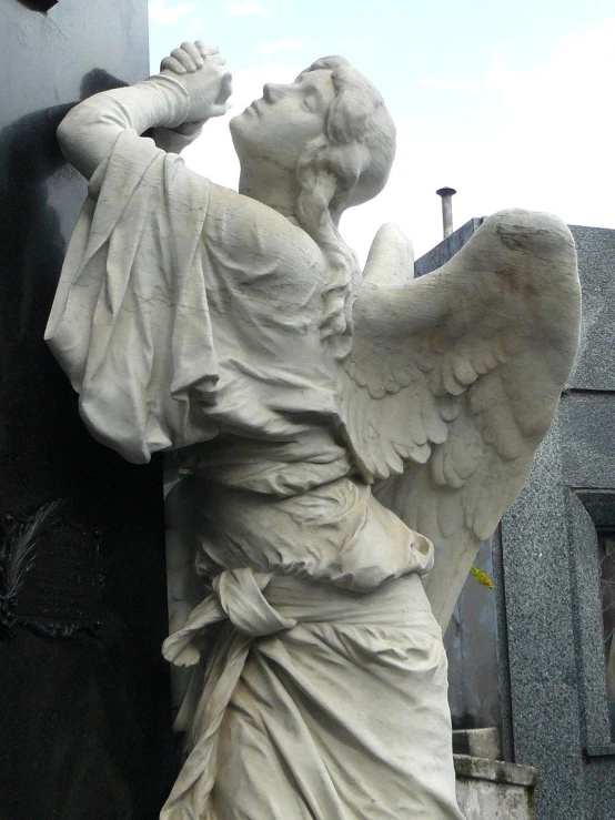 an angel statue standing outside of a cemetery