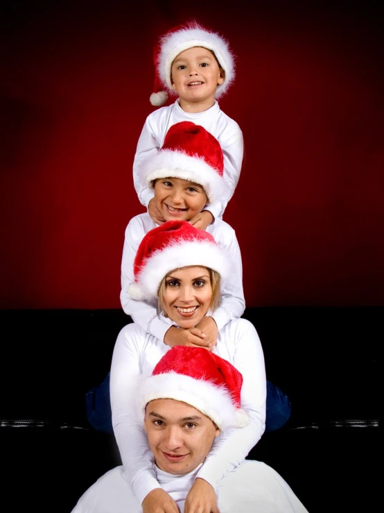 two women and three children in santa's hats pose for a po