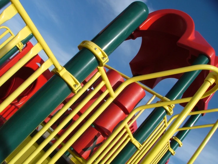 a green red and yellow playground structure with no slide