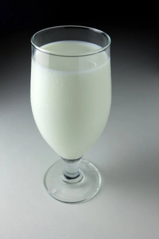 a tall glass is filled with milk