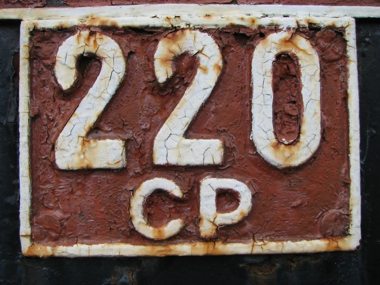 a rusted out sign has the numbers 20, twenty and five painted on it